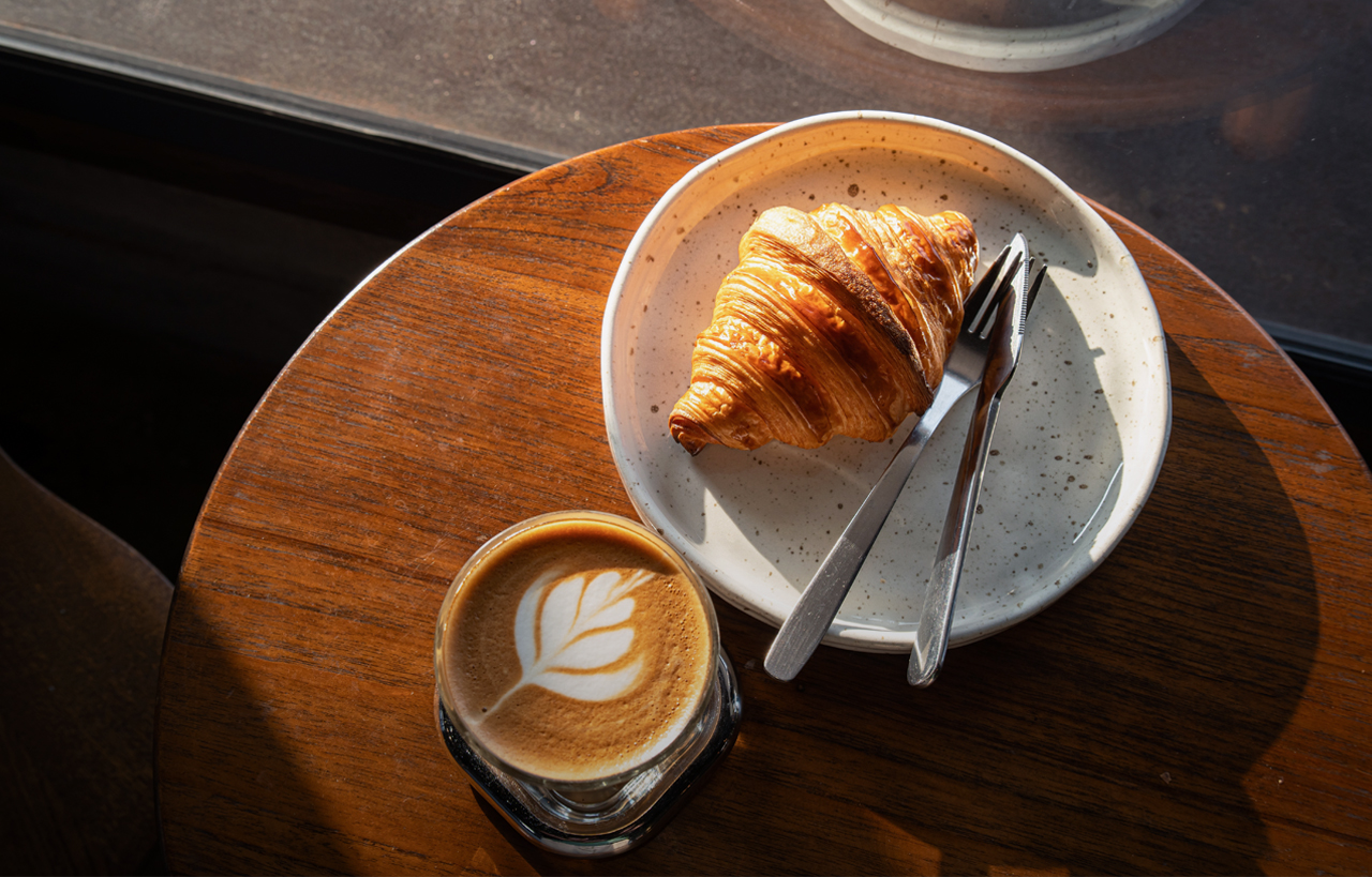 Bild von einem Croissant und einem Kaffee auf einem runden Tisch | Cafe Bad Kissingen